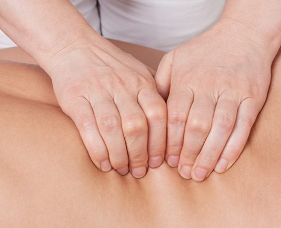 Sport professional massage on a muscle group (erector spinae muscles) of a womans back